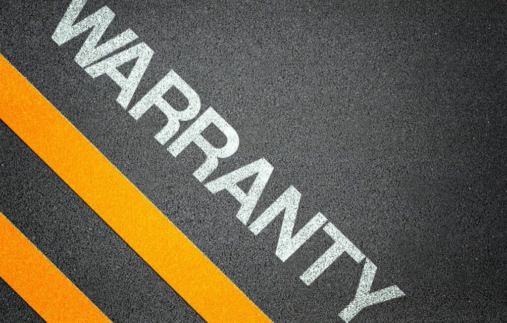 Close-up of the word “warranty” on a textured surface, illustrating key concepts in solar panel warranties for New York State Solar Farm