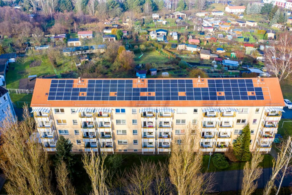 Aerial view of a large solar panel system installed on an apartment building roof