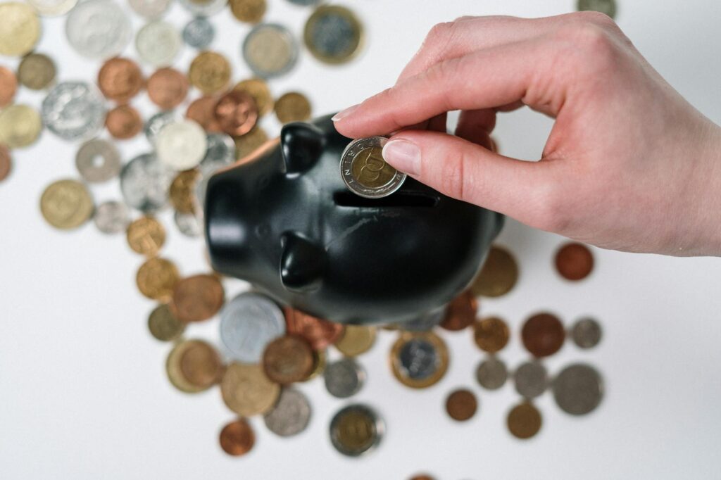 A person putting a coin into a piggy bank, representing solar energy savings and permit costs