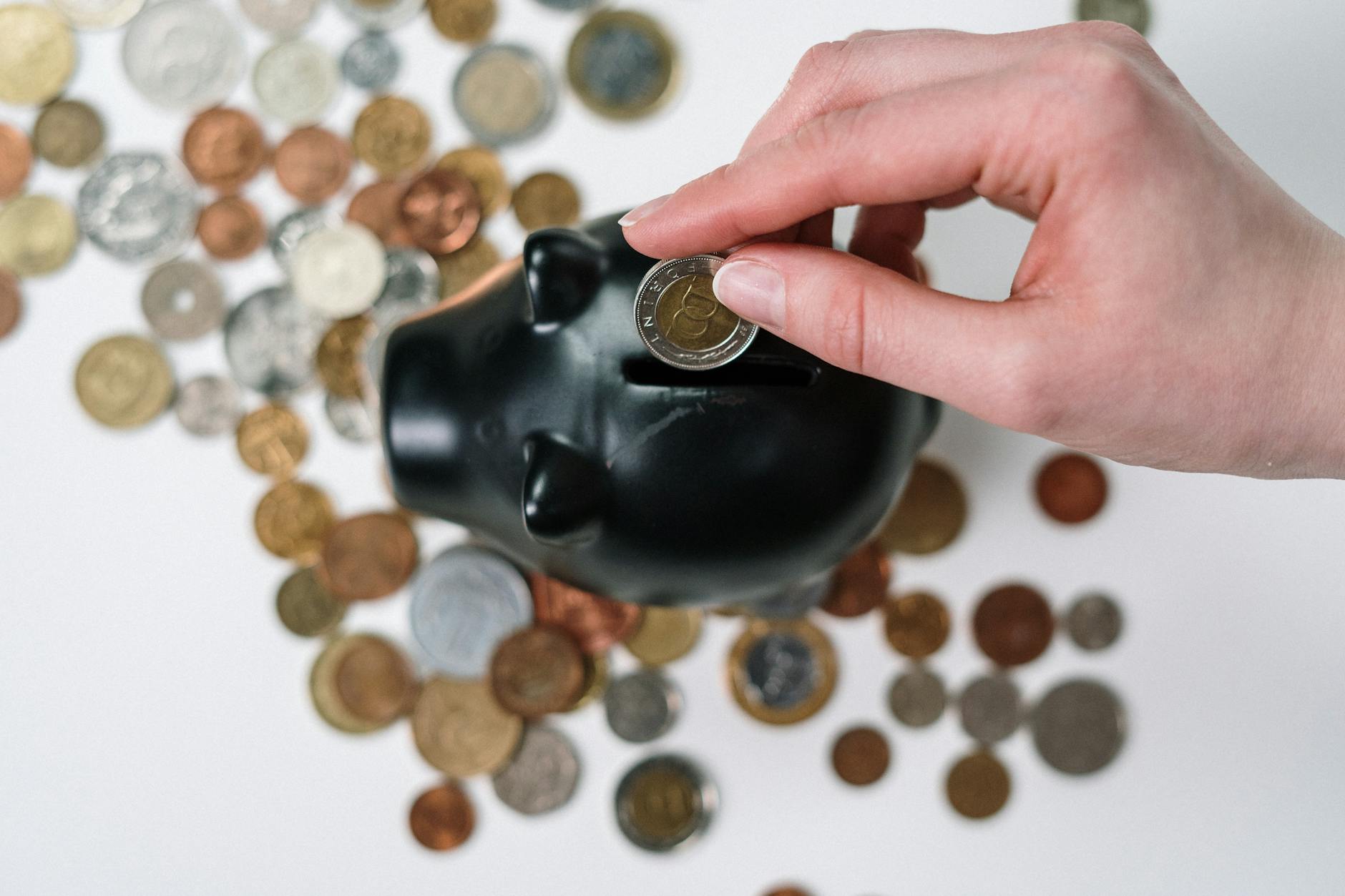 A person putting a coin into a piggy bank, representing solar energy savings and permit costs