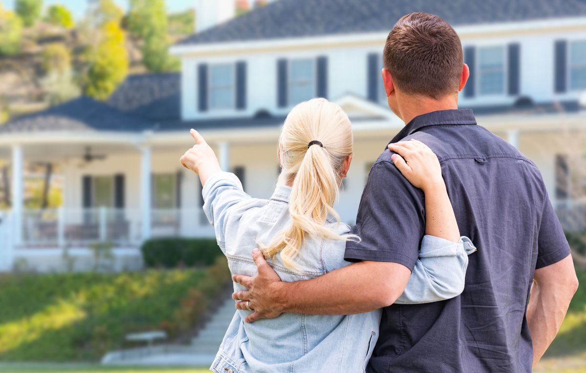Homeowners looking at a house while choosing a solar installer