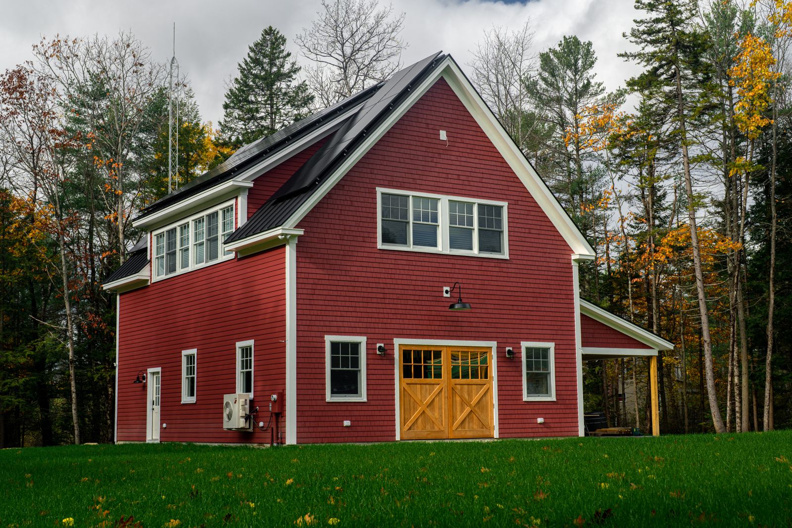 Home with rooftop solar panels surrounded by autumn trees, representing Hudson Valley homes taking part in a virtual power plant