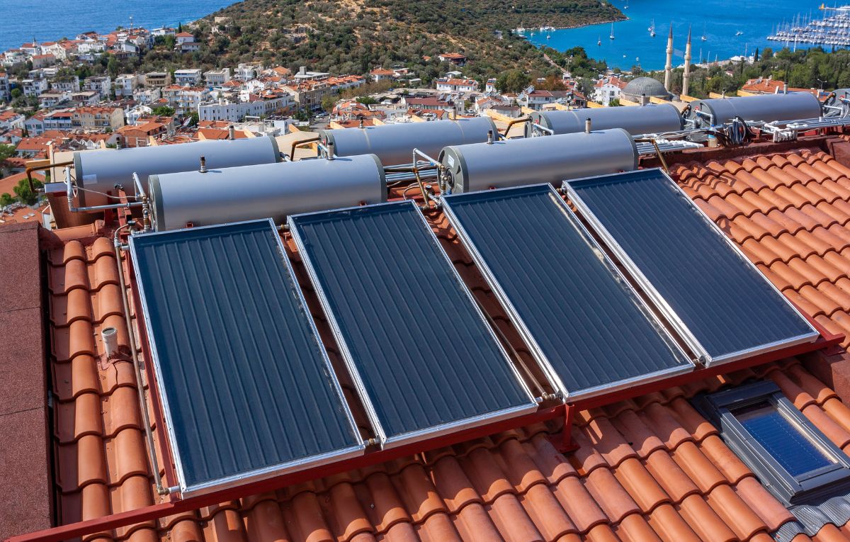 Rooftop solar thermal collectors and storage tanks overlooking coastal town